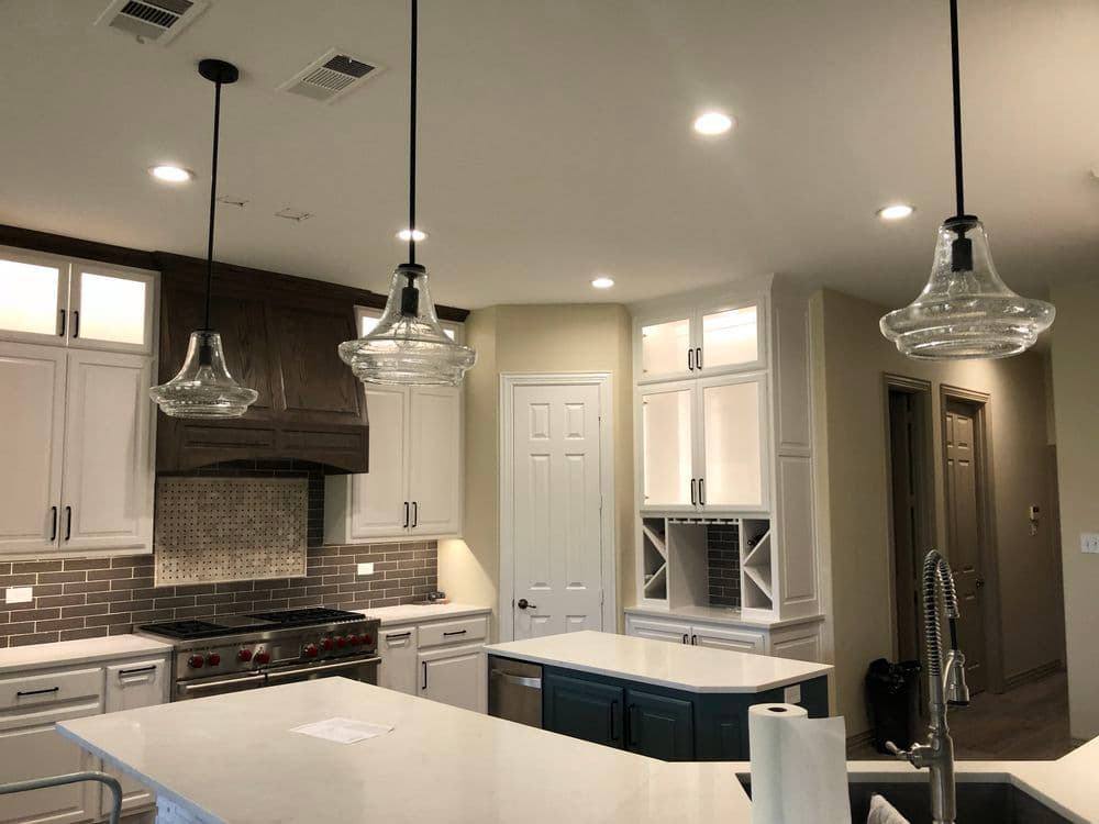 Modern kitchen with pendant lights, stylish cabinetry, and stainless steel appliances.